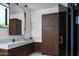 Chic bathroom featuring marble countertops, dark wood cabinets, and glass-enclosed shower at 5814 E Camelback Rd, Phoenix, AZ 85018