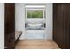 Bright bathroom with a modern soaking tub and view to greenery through the window at 5814 E Camelback Rd, Phoenix, AZ 85018
