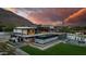 Stunning modern home with a pool, basketball court, and mountain views at sunset at 5814 E Camelback Rd, Phoenix, AZ 85018