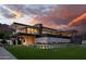 Modern home at sunset with manicured lawn and flowerbeds, concrete accents, and covered outdoor living space at 5814 E Camelback Rd, Phoenix, AZ 85018