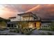 Modern two-story home with a balcony and a well-manicured front yard at sunset at 5814 E Camelback Rd, Phoenix, AZ 85018