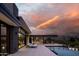 Modern home featuring an infinity pool and outdoor kitchen with bar seating at sunset at 5814 E Camelback Rd, Phoenix, AZ 85018