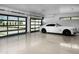 Spacious garage featuring a white luxury car, epoxy flooring, and glass-paneled garage doors at 5814 E Camelback Rd, Phoenix, AZ 85018