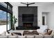 Modern living room with fireplace, TV, and comfortable seating area by large windows at 5814 E Camelback Rd, Phoenix, AZ 85018