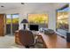 Bright home office featuring wood desk with desert views and a sliding glass door to an outdoor patio at 6001 E Restin Rd, Cave Creek, AZ 85331