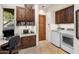 Convenient laundry room with built-in desk, wooden cabinetry and modern washer and dryer at 6001 E Restin Rd, Cave Creek, AZ 85331