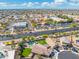 Expansive aerial view of a home with a private pool and lush green yard, surrounded by a vibrant neighborhood at 6763 W Wethersfield Rd, Peoria, AZ 85381