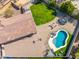 Aerial shot of a backyard featuring a pristine pool, a trampoline and brick patio with table and chairs at 6763 W Wethersfield Rd, Peoria, AZ 85381
