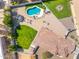 Aerial image showcasing a backyard with a pool, trampoline, firepit, a paved patio, and lawn at 6763 W Wethersfield Rd, Peoria, AZ 85381