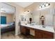 Spacious bathroom boasting double sinks, wood-look flooring, and a door that leads to the main bedroom at 6763 W Wethersfield Rd, Peoria, AZ 85381