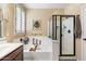 Elegant bathroom features a soaking tub with candles, a shower with glass door, and plantation shutters at 6763 W Wethersfield Rd, Peoria, AZ 85381