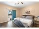 Well-lit bedroom with hardwood flooring and a sliding glass door leading to the backyard at 6763 W Wethersfield Rd, Peoria, AZ 85381