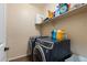 Efficient laundry area with modern washer and dryer and ample storage shelving at 6763 W Wethersfield Rd, Peoria, AZ 85381
