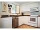 Cozy kitchen featuring a window, stainless steel dishwasher, and white appliances at 7575 E Indian Bend Rd # 1012, Scottsdale, AZ 85250