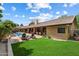 Expansive backyard featuring a pool, patio area, manicured lawn, and lush landscaping at 8272 S Pecan Grove Cir, Tempe, AZ 85284