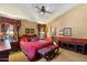 Warm bedroom featuring decorative curtains, accent wall, ceiling fan, and comfortable furnishings at 8272 S Pecan Grove Cir, Tempe, AZ 85284