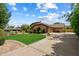 Charming single-Gathering home with a well-manicured lawn, landscaping, and a long driveway leading to an attached garage at 8272 S Pecan Grove Cir, Tempe, AZ 85284