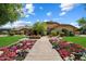 Inviting single-Gathering home with lush landscaping, including flowerbeds, and a welcoming walkway to the entrance at 8272 S Pecan Grove Cir, Tempe, AZ 85284