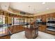 Gourmet kitchen with granite countertops, island, custom cabinetry, and stainless steel appliances at 8272 S Pecan Grove Cir, Tempe, AZ 85284