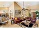 Open-concept living room featuring high ceilings, fireplace, and comfortable seating with views into the kitchen and dining areas at 8272 S Pecan Grove Cir, Tempe, AZ 85284