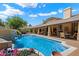 Large, pristine pool with a built-in water feature and verdant landscaping at 8272 S Pecan Grove Cir, Tempe, AZ 85284