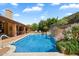 Sparkling pool with waterfall feature, surrounded by lush greenery and a spacious patio at 8272 S Pecan Grove Cir, Tempe, AZ 85284
