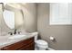 A half-bathroom features a toilet, sink, dark wood cabinets and granite countertops at 1051 E Julie Ave, San Tan Valley, AZ 85140