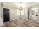 Open dining area with wood-look floors, stylish lighting, and an archway leading to another room at 1051 E Julie Ave, San Tan Valley, AZ 85140