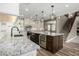 A spacious kitchen with granite countertops, stainless steel appliances, and a dark wood island at 1051 E Julie Ave, San Tan Valley, AZ 85140