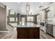 A kitchen boasts a dark wood island, stone countertops, and stainless steel appliances at 1051 E Julie Ave, San Tan Valley, AZ 85140