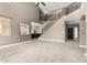 Open-concept living area with a view of the kitchen, staircase, and front entry with wood and iron railing at 1051 E Julie Ave, San Tan Valley, AZ 85140