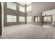 Spacious living room featuring high ceilings, large windows, neutral carpeting, and an open layout at 1051 E Julie Ave, San Tan Valley, AZ 85140