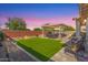Relaxing backyard featuring a covered patio, artificial grass, and a charming pergola seating area at 14640 W Dahlia Dr, Surprise, AZ 85379