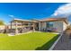 Backyard with an outdoor kitchen, lush green lawn, and a covered patio with furniture at 14640 W Dahlia Dr, Surprise, AZ 85379