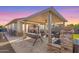Covered patio with stone accents, outdoor swing, and fire pit offers an inviting relaxation space at 14640 W Dahlia Dr, Surprise, AZ 85379