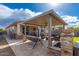 Covered patio with stone accents, outdoor swing, and fire pit offers an inviting relaxation space at 14640 W Dahlia Dr, Surprise, AZ 85379