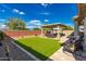 Relaxing backyard featuring a covered patio, artificial grass, and a charming pergola seating area at 14640 W Dahlia Dr, Surprise, AZ 85379