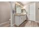 Bright bathroom with dual sinks, wood-look flooring, and updated lighting, creating a serene space at 14640 W Dahlia Dr, Surprise, AZ 85379
