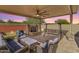 Inviting covered patio with ample seating, a water feature, and a cozy swing for outdoor relaxation at 14640 W Dahlia Dr, Surprise, AZ 85379