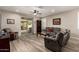 Comfortable living room with stylish seating, a ceiling fan, sliding glass doors to patio, and neutral decor at 14640 W Dahlia Dr, Surprise, AZ 85379