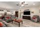 Open-concept living room showcasing wood-look flooring, comfortable furniture, and seamless flow to dining area at 14640 W Dahlia Dr, Surprise, AZ 85379