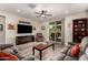 Inviting living room with wood floors, a ceiling fan, comfortable seating, and sliding door to patio at 14640 W Dahlia Dr, Surprise, AZ 85379