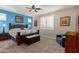A well-lit main bedroom features a ceiling fan, shuttered windows, and carpeting, offering a cozy retreat at 14640 W Dahlia Dr, Surprise, AZ 85379