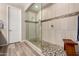 An updated shower boasts decorative tile, glass enclosure, and a built-in seat at 14640 W Dahlia Dr, Surprise, AZ 85379