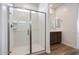 Bright bathroom featuring a glass-enclosed shower and a single sink vanity with dark wood cabinets at 14739 W El Cortez Pl, Surprise, AZ 85387