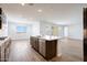 Spacious kitchen with wood flooring, island with stainless steel dishwasher and sink, gas range, and modern design at 14739 W El Cortez Pl, Surprise, AZ 85387