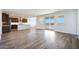 Open concept living space featuring kitchen with island, wood flooring, sliding glass doors, and plentiful natural light at 14739 W El Cortez Pl, Surprise, AZ 85387