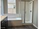 Bright bathroom showcasing a soaking tub with a window view and a separate glass-enclosed shower at 15911 W Montana De Oro Dr, Surprise, AZ 85387
