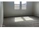 Light-filled bedroom with plush carpeting and ample natural light from the two well-sized windows at 15911 W Montana De Oro Dr, Surprise, AZ 85387