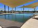 Large community pool showcasing a tranquil swimming space, set against a clear blue sky and mature palm trees at 15911 W Montana De Oro Dr, Surprise, AZ 85387